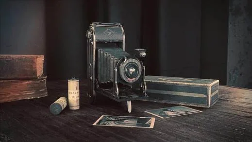 A photoreal vintage folding camera staged with film boxes and prints, built as a hero interactive prop