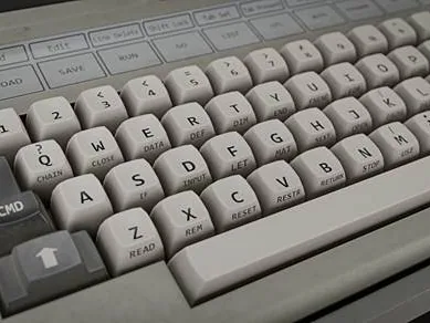 Close detail of a beige retro computer keyboard with worn moulded keycaps